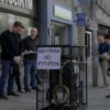 A realistic photograph of a modern Russian city street in Yaroslavl, showing a clearly marked and safely removed trap or device that was previously used to catch pythons, with people nearby observing the removal, no text or symbols on the image, clean and natural lighting